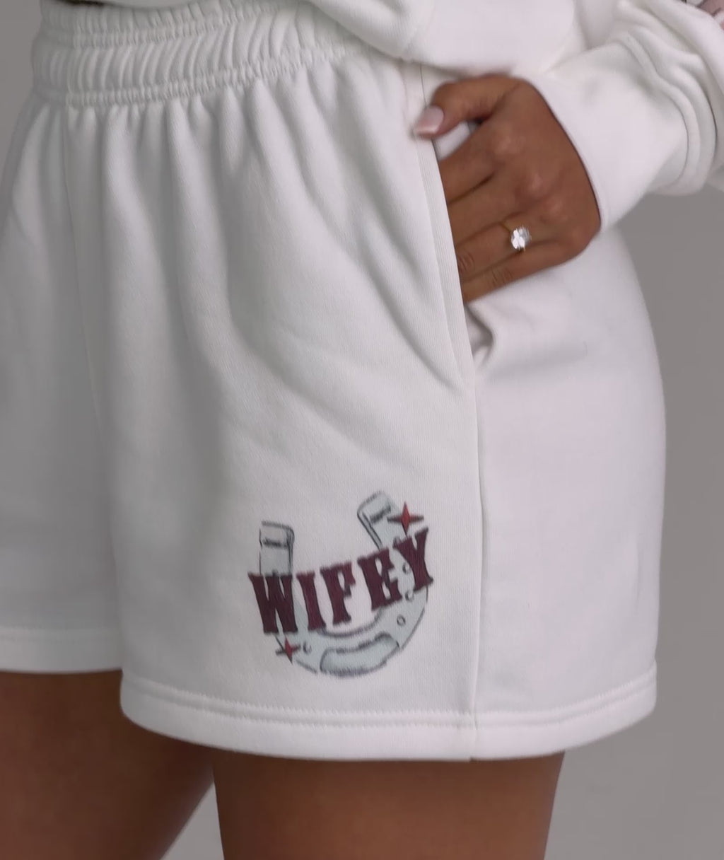 Bride wearing rodeo shorts and sweatshirt – cowgirl outfit
